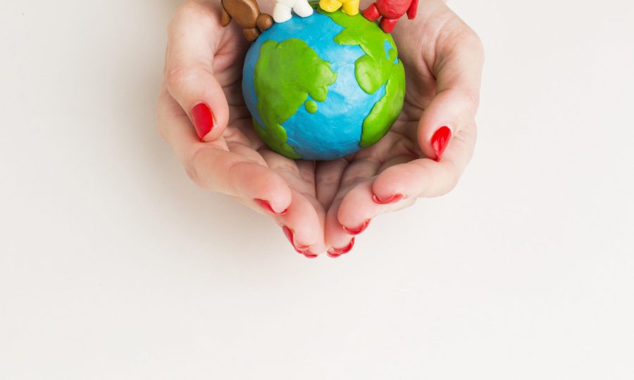 top-view-hands-holding-globe-with-people-figurines
